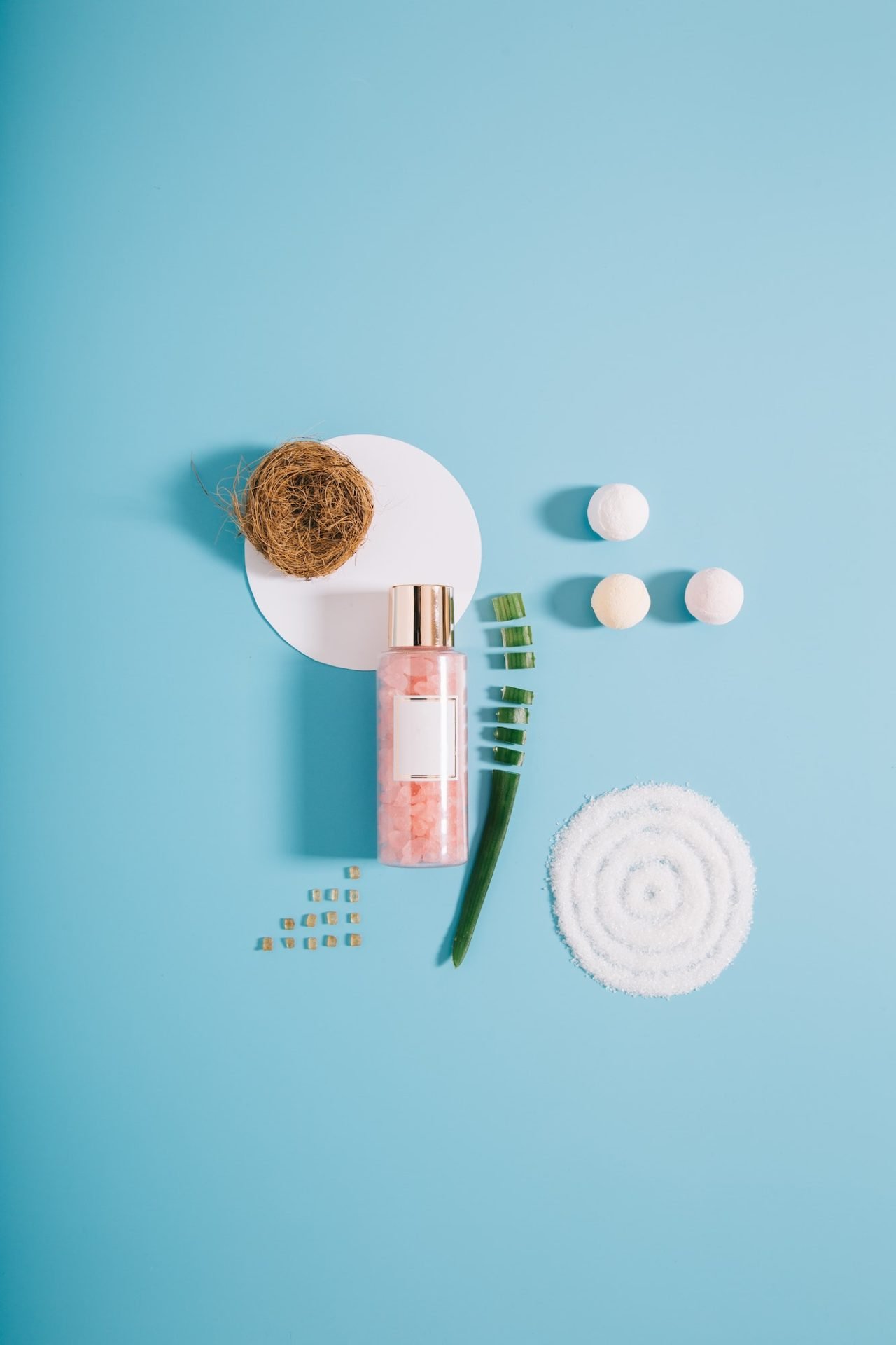 mockup spa bottle with pink bath salt on blue background .jpg