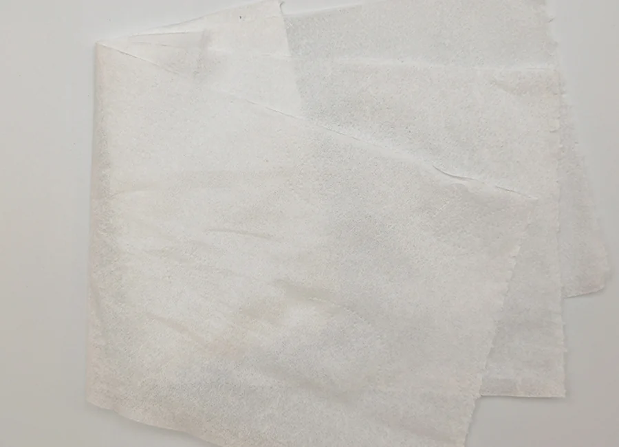 Folded low-lint wipes beside clean automotive components