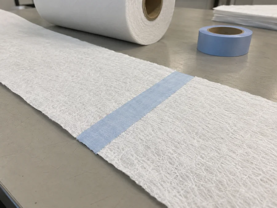 Pale blue splice tape across two aligned white airlaid web samples
