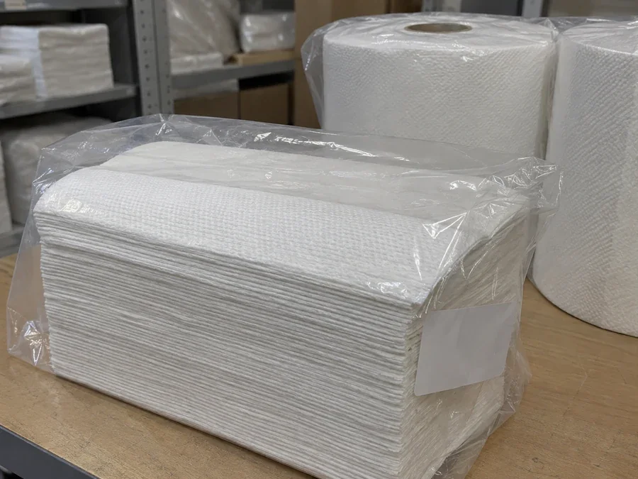 Wrapped folded towel stack beside towel rolls