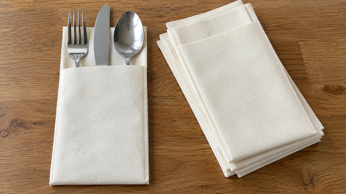 Airlaid napkin supplier format example: ivory cutlery pocket holding a fork, knife and spoon